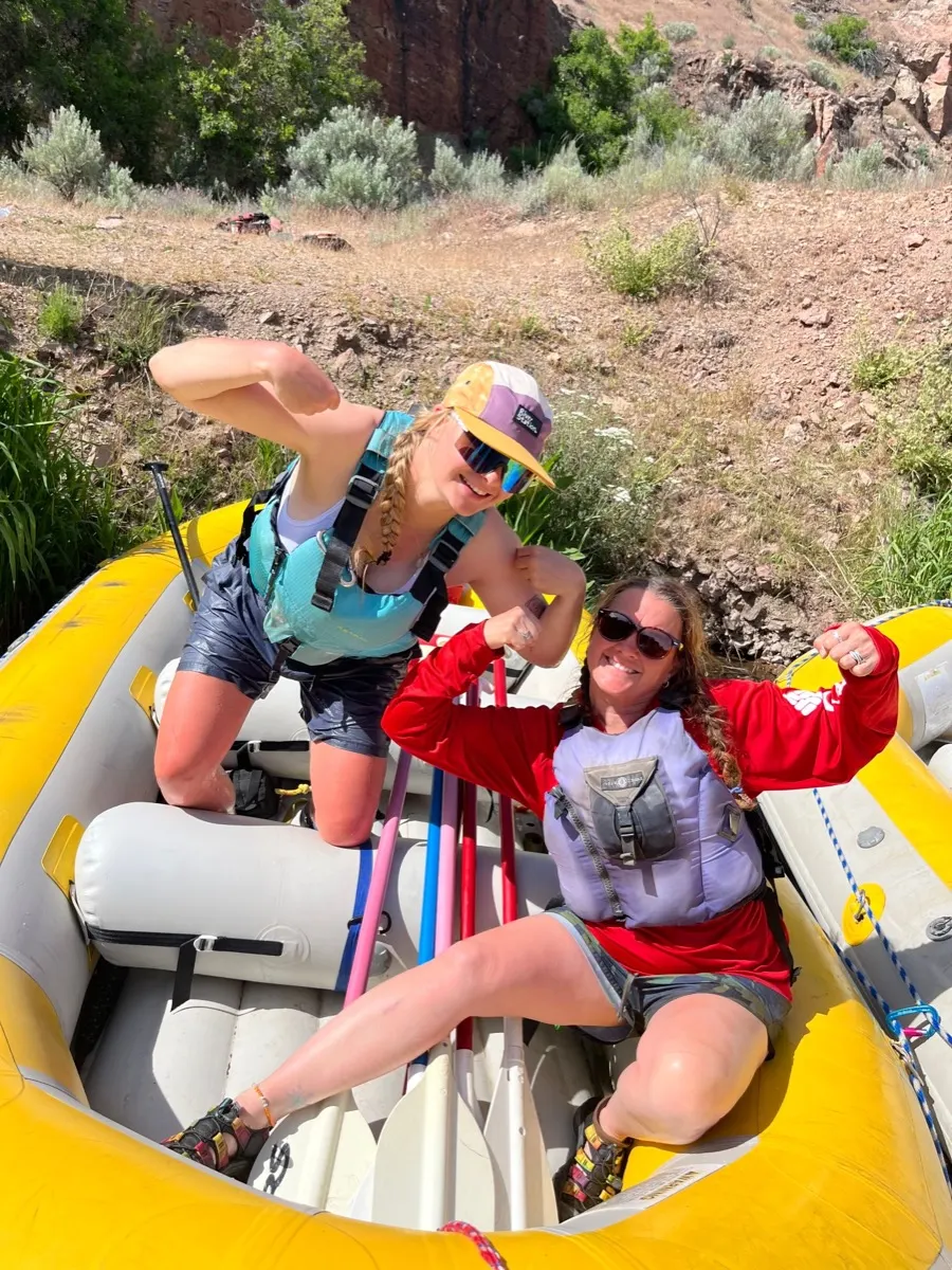 Two McCoy guides laughing in a yellow raft